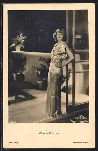 AK Schauspielerin Greta Garbo lehnt im Abendkleid an einer Glastür