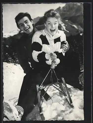 AK Schauspielerin Romy Schneider & Schauspieler Horst Buchholz rodeln auf einem Schlitten im Schnee