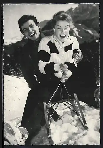 AK Schauspielerin Romy Schneider & Schauspieler Horst Buchholz rodeln auf einem Schlitten im Schnee