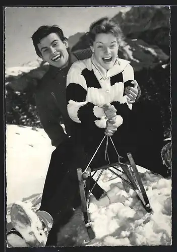 AK Schauspielerin Romy Schneider & Schauspieler Horst Buchholz rodeln auf einem Schlitten im Schnee