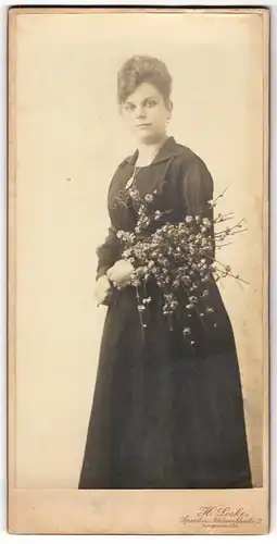 Fotografie H. Leske, Spandau, junge Frau im dunklen Kleid mit blühenden Strauch im Arm