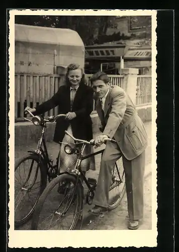 Foto-AK Lächelndes Paar mit Fahrrädern