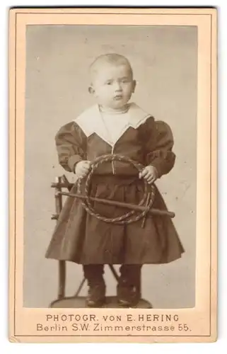 Fotografie Ernst Hering, Berlin, Zimmerstr. 55, Kind im Matrosenkleid mit Peitsche