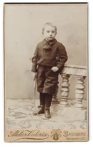 Fotografie Atelier Victoria, Bromberg, Danzigerstr. 157, Junge in schlichter Kleidung mit Peitsche