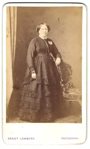 Fotografie Ernst Lomberg, Langenberg, Bürgerliche Dame mit weitem Kleid und einer Ansteckschleife