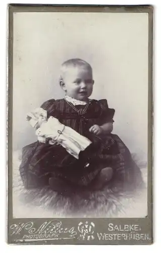 Fotografie W. Nilius, Salbke-Westerhüsen, Junges Mädchen im Kleid mit ihrer Puppe