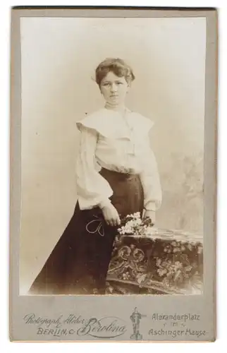 Fotografie Atelier Berolina, Berlin C., Alexanderplatz, Junge Dame im weissen Kleid mit einem kleinen Bouquet Blumen