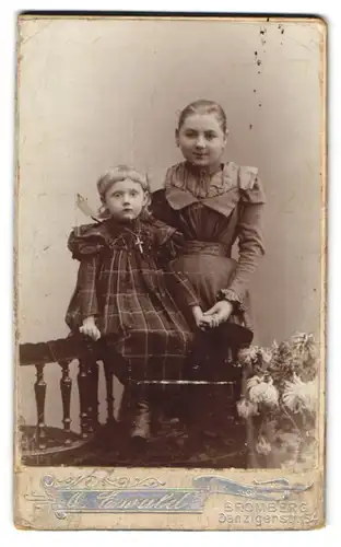 Fotografie O. Ewald, Bromberg, Danzigerstr. 154, Mädchen im eleganten Kleid mit ihrer kleinen Schwester