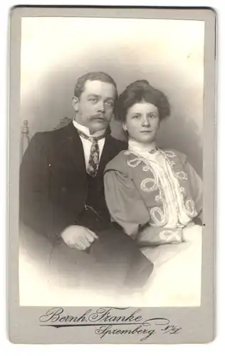 Fotografie Bernh. Franke, Spremberg /N.-L., Bürgerliches Ehepaar in eleganter Abendkleidung, sie in seinem Arm