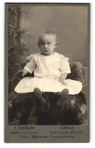 Fotografie Atelier St. Lorenz, Lübeck, Schwartauer Allee 12c, Kleines Mädchen im weissen Kleid auf einem Pelz