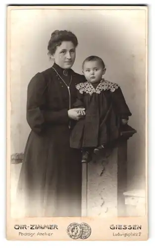 Fotografie Chr. Zimmer, Giessen, Ludwigsplatz 2, Stolze Mutter mit einer Brosche am Kragen und ihrer kleinen Tochter