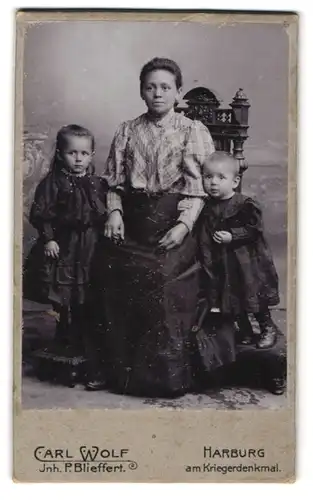 Fotografie Carl Wolf, Harburg, Am Kriegerdenkmal, Mutter auf einem Stuhl mit ihren beiden Kindern
