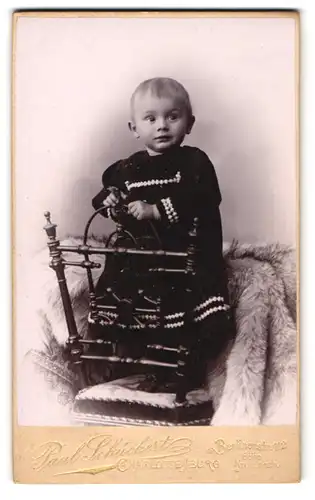 Fotografie Paul Schückert, Charlottenburg, Berlinerstr. 112, Kleines Kind im Kleid steht auf einem Stuhl