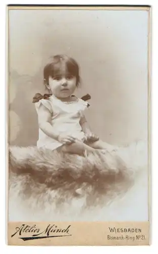 Fotografie Atelier Münch, Wiesbaden, Bismarck-Ring 21, Kleines Kind im Hemd sitzt auf einem Fell