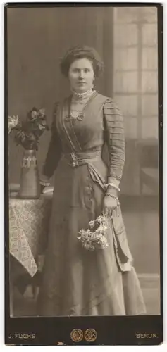 Fotografie F. Fuchs, Berlin, Dame im Kleid mit Blumenstrauss in der Hand