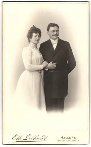 Fotografie Otto Gebhardt, Halle / Saale, Ehepaar im weissen Kleid und im dunklen Anzug mit Zwickerbrille
