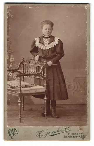 Fotografie H. Joseph & Co., Rixdorf, Berlinerstr. 55, Mädchen mit elegantem Kleid mit Zierelementen am Kragen