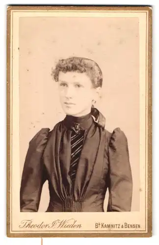 Fotografie Theodor Wieden, Bensen, Schlanke junge Dame mit einer Putten-Brosche am Kragen