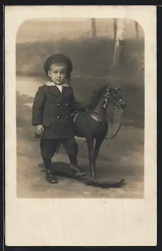 Foto-AK Kleiner niedlicher Junge mit Schaukelpferd und Matrosenmütze