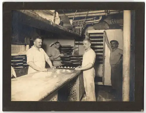 Fotografie unbekannter Fotograf und Ort, Bäcker in der Backstube beim Brötchen backen