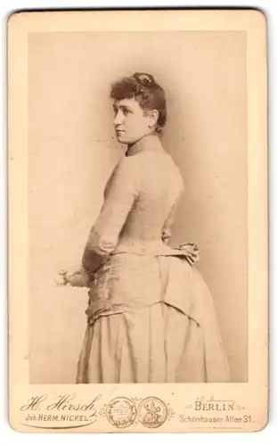 Fotografie H. Hirsch, Berlin, Schönhauser Allee 31, Bürgerliche Dame im taillierten Kleid mit einer Blume in der Hand