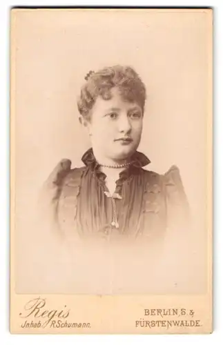 Fotografie Atelier Regis, Berlin S., Prinzenstr. 44, Junge Dame im schwarzen Kleid mit Puffärmeln und Perlenkette