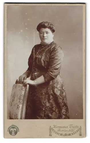Fotografie Hermann Tietz, Berlin S. W., Leipziger-Str., Füllige bürgerliche Dame mit elegantem floral gemusterten Kleid