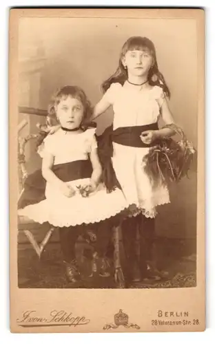 Fotografie J. von Schkopp, Berlin, Veteranen-Str. 28, Zwei junge Schwestern im Partnerkostüm, eine stehend, eine sitzend