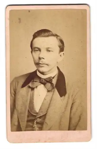 Fotografie F. Karwatcky, Boizenburg a. E., Junger Mann in Sakko mit auffälligem Revers und Fliege, mit Schnurrbart