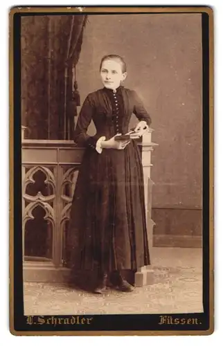 Fotografie L. Schradler, Füssen, Junge Dame im eleganten, taillierten Kleid mit einem aufgeschlagenen Buch