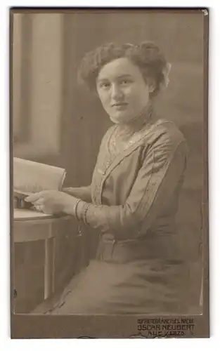 Fotografie Oscar Neubert, Aue i. Erzg., Junge Dame mit einer Schleife im Haar und schickem Anhänger am Armband