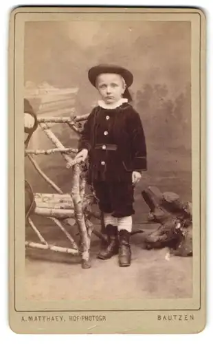 Fotografie A. Matthaey, Bautzen, Kleiner Junge in Sonntagsgarderobe mit Rüschenkragen und einem Hut