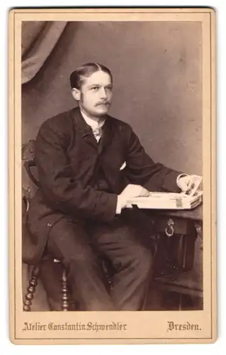 Fotografie Constantin Schwendler, Dresden, Sophieenstrasse 5, Junger Mann mit striktem Mittelscheitel am Fotoalbum