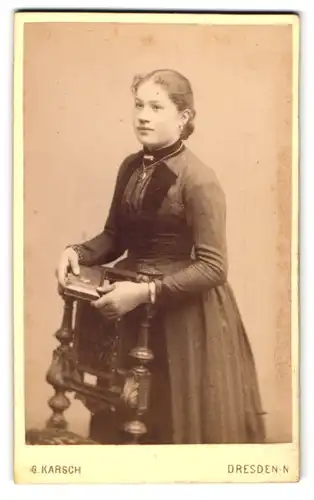 Fotografie G. Karsch, Dresden N., Gr. Meissenerstr. 17, Junge Dame im taillierten Kleid mit einem Portrait-Medaillon
