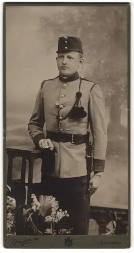 Fotografie J. Kügemann, Carlsbad, Portrait junger K.u.K. Soldat Oskar Russ in Uniform mit Schützenschnur und Bajonett