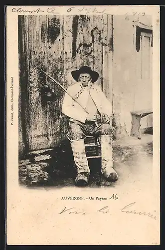 AK Bauer in Tracht der Auvergne vor dem Haus sitzend