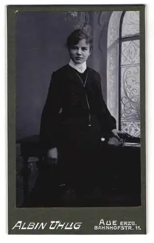 Fotografie Albin Uhlig, Aue /Erzg., Bahnhofstr. 11, Jugendliches Mädchen im langen schwarzen Kleid mit weissem Stehkragen