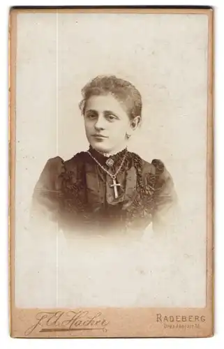 Fotografie F. A. Hacher, Radeberg, Dresdnerstr. 18, Junge Dame mit elegant verziertem Kleid und einer Kreuzkette