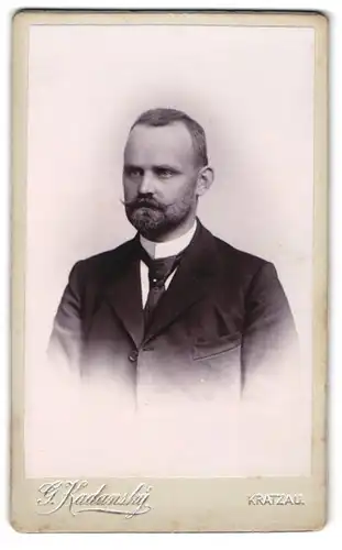 Fotografie G. Kadanský, Kratzau, Eleganter Herr mit Vollbart u. Krawatte in schlichtem Anzug