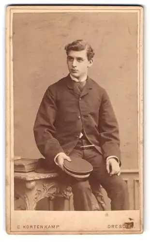 Fotografie C. Kortenkamp, Dresden, Annenstrasse 10, Junger Herr in schlichtem Anzug mit Scheitel u. Mütze