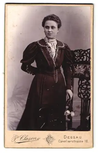 Fotografie P. Clasen, Dessau, Cavalierstr. 16, Hübsche Bürgertochter in tailliertem Kleid mit Kette u. Rosen