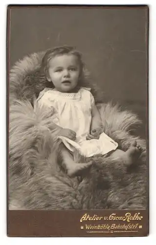 Fotografie Oskar Rothe, Dresden, Schäferstr. 32, Kind in weissem mit Kleid u. offenem Mund auf Fell