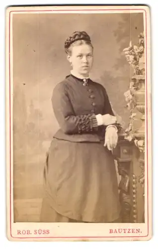 Fotografie Robert Süss, Bautzen, Tuchmacher-Gasse 668, Hübsche Bürgertochter mit Flechtfrisur in geknöpftem Kleid