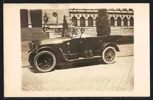 Foto-AK Auto Benz, Zwei junge Männer in einem KFZ vor einem grossen Gebäude