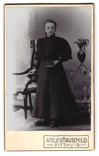 Fotografie Atelier Hauschild, Zittau i. S., Cirkus Allee 4, Bürgertochter in schwarzem tailliertem Kleid mit Buch