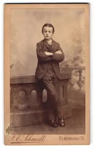 Fotografie F. E. Schmidt, Olbernhau i. S., Junger Herr mit Mittelscheitel und verschränkten Armen
