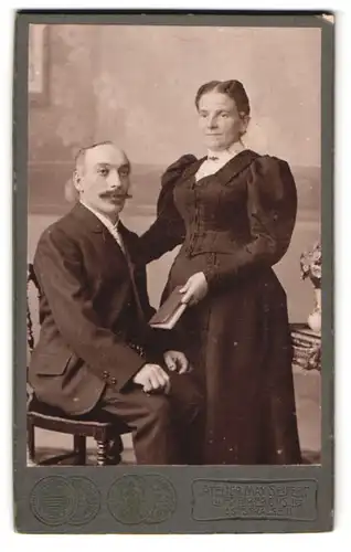 Fotografie Max Seifert, Freiberg i. S., Poststr. 11, Ältere Dame in tailliertem Kleid neben Ehemann mit Schnauzbart