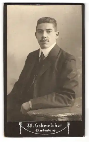Fotografie M. Schmelcher, Lindenberg, Junger Herr mit Oberlippenbart u. markanten Brauen in Nadelstreifenanzug