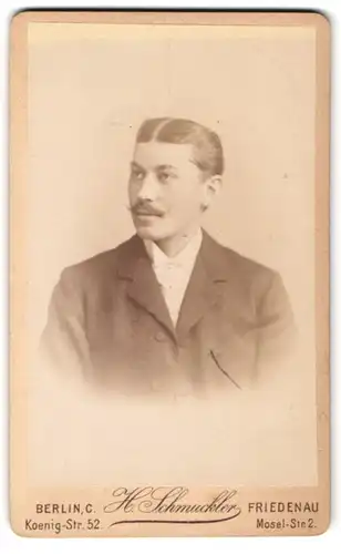 Fotografie H. Schmuckler, Berlin, Koenig-Str. 52, Junger Herr mit Mittelscheitel u. Schnauzbart in schlichtem Anzug