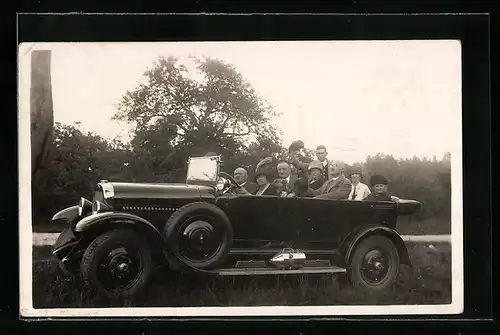 Foto-AK Auto, Vollbesetztes schwarzes Fahrzeug auf einer Wiese